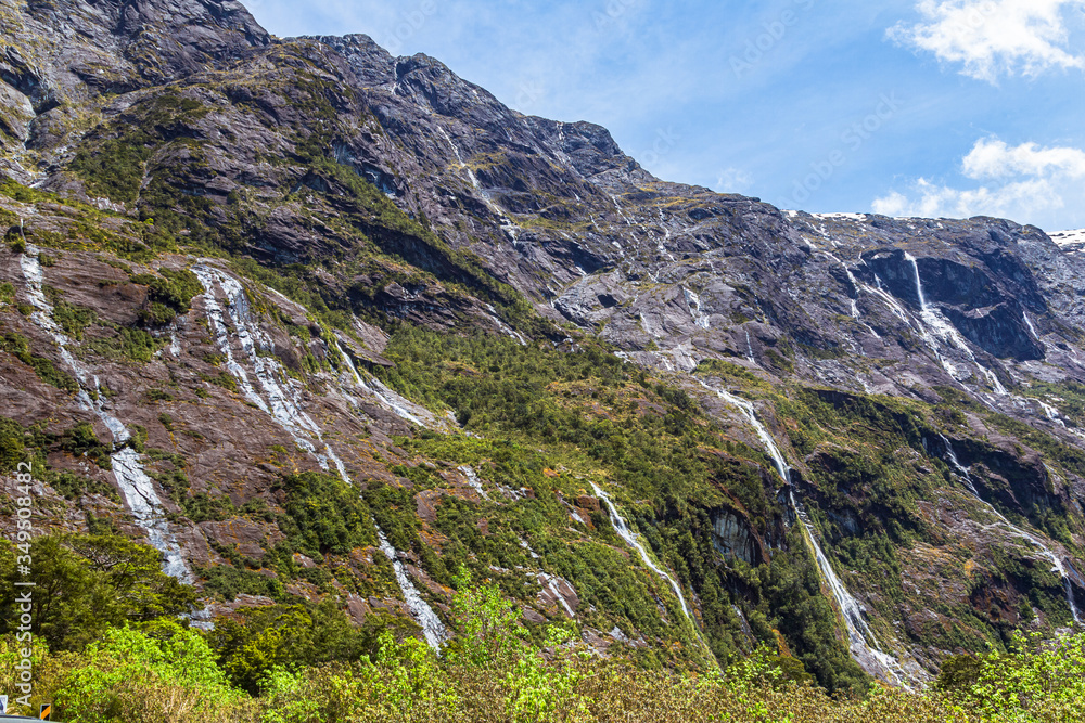Small waterfalls and streams from sheer cliffs on the way to Fiordland. South Island, New Zealand