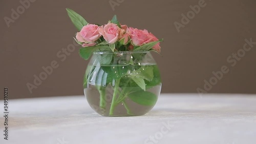 Close up of beautiful bouquet of pink roses in transparent vase.