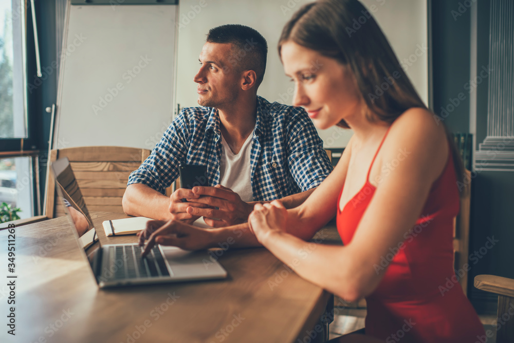 Obraz premium Dreaming freelancer using smartphone working with partner