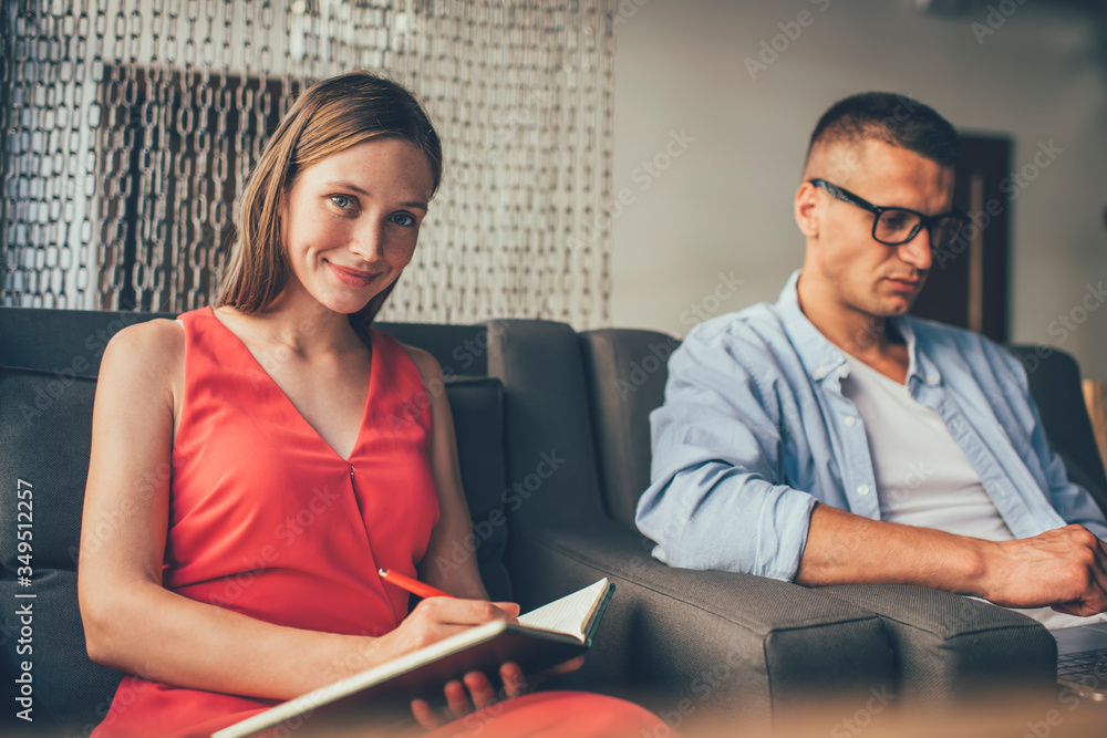 Fototapeta premium Stylish couple checking information using laptop and notebook