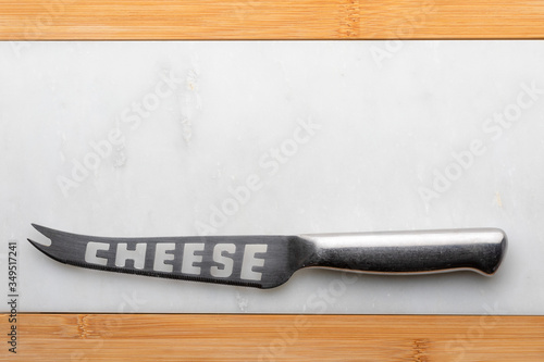 Empty cheese board with knife. Copy Space White marble and wood. Top View. photo