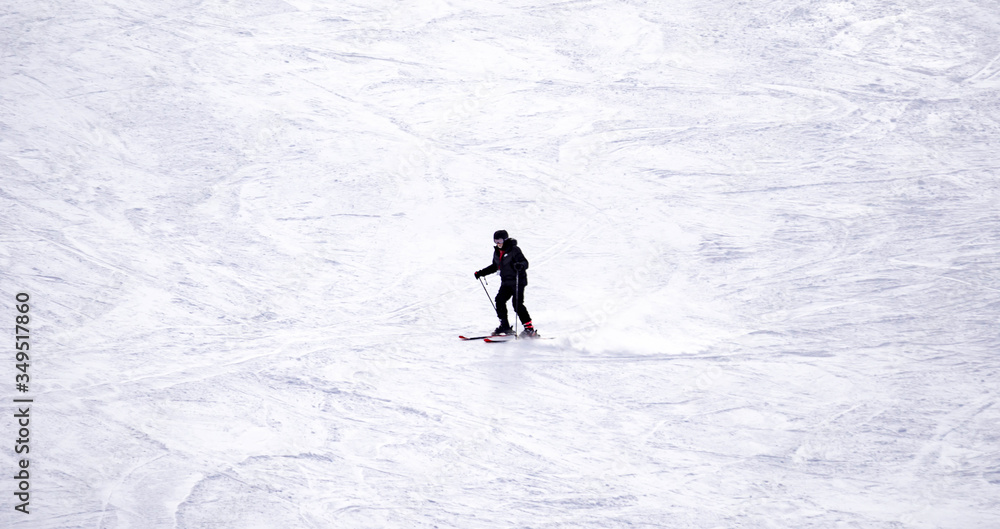 Full length of skier skiing on fresh powder snow. Man skier running downhill on sunny Alps slope Full length of skier skiing on fresh powder snow. Man skier running downhill on sunny Alps slope