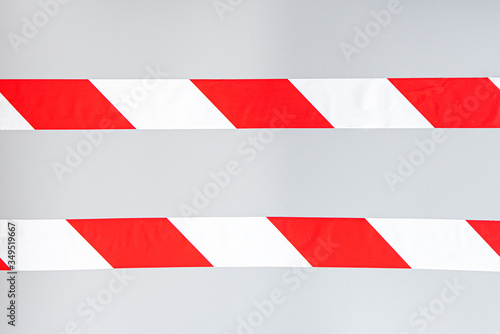 Red white signal striped interdictory tape. Striped line isolated on gray background. Plastic warning tape.  photo