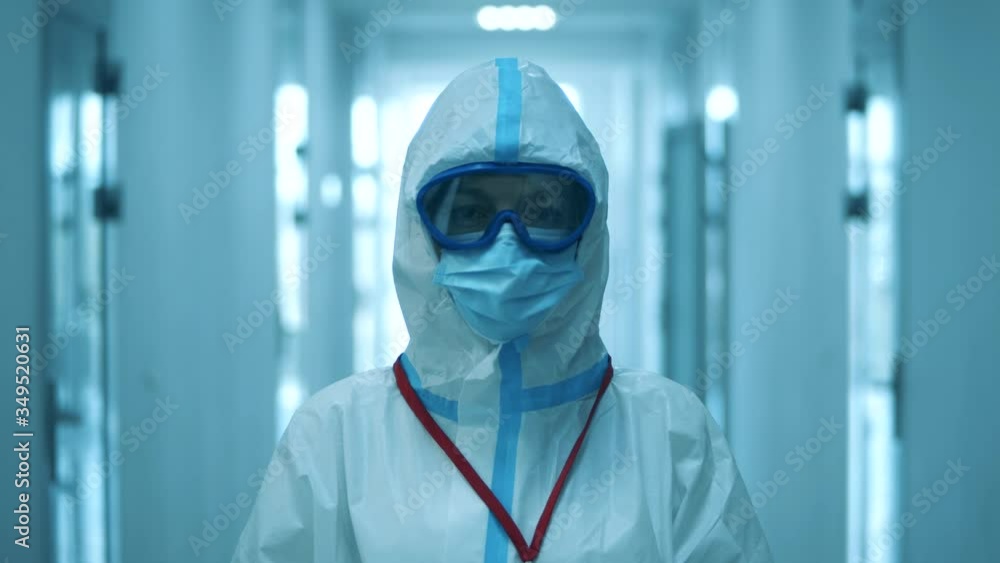 A woman looks at camera, while wearing protective suit. A woman looks at camera, while wearing protective suit.