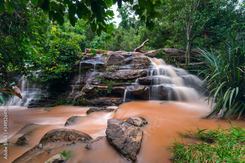 Red Waterfall and black rocks in Chaiyapoom Thailand.Theppana Waterfall.leaf moving low speed shutter blur. photo