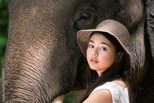 Elephants and tourists in the forest. Tourism asian women holding camera in elephant village.