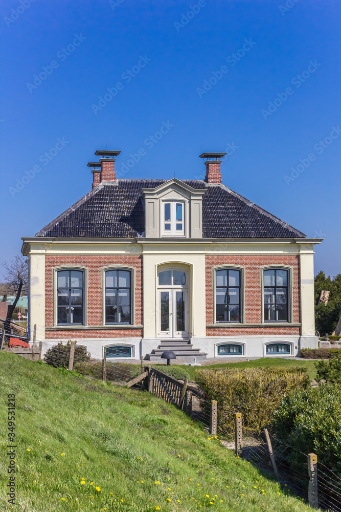 Historic house behind the dike in Zoutkamp, Netherlands Historic house behind the dike in Zoutkamp, Netherlands