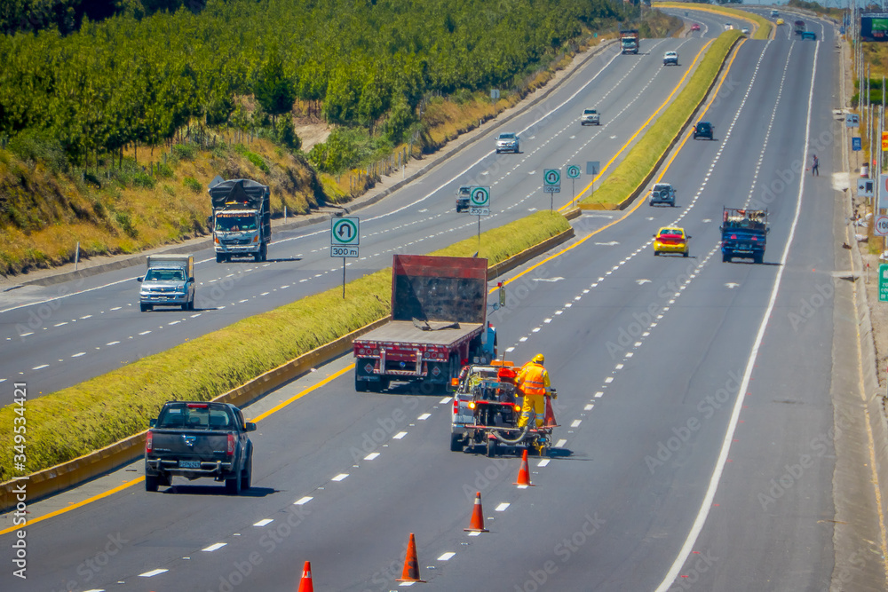 Cotopaxi, ECUADOR - 08 September 2019: Workmen painting lines on road. Road line car painting white lines and central road line marking.