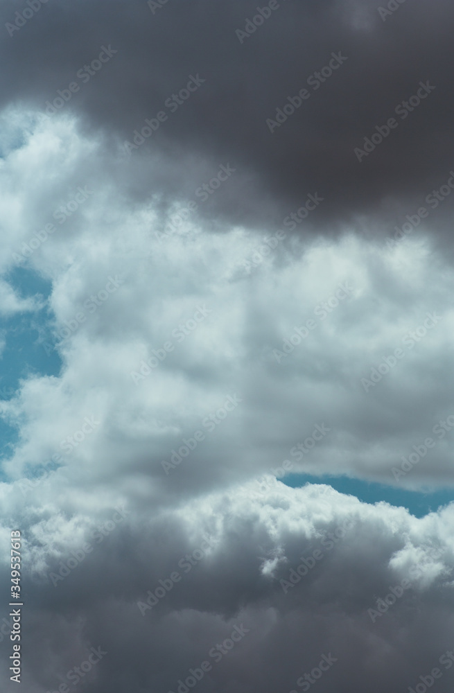 Fluffy clouds cover the summer blue sky