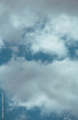 Fluffy clouds cover the summer blue sky