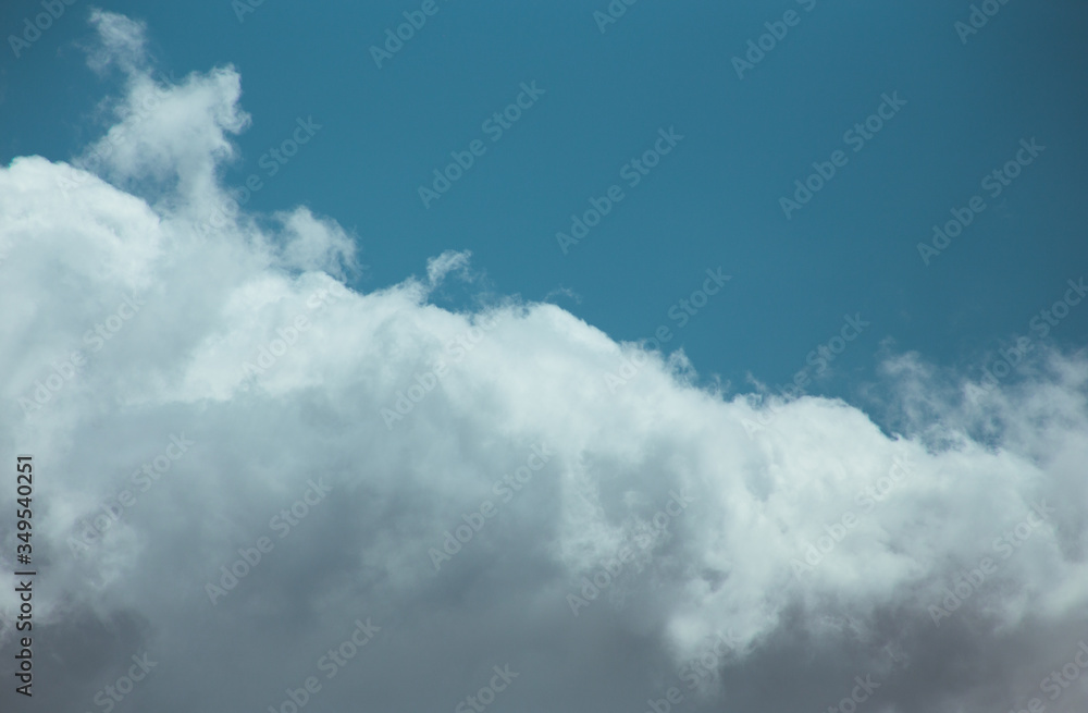Obraz premium Fluffy clouds cover the summer blue sky