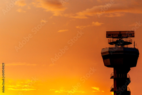 Silhouettes of radar tower on sky background at sunrise