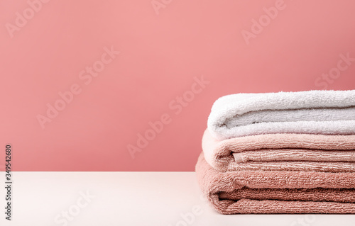Stack of bath towels on pink background