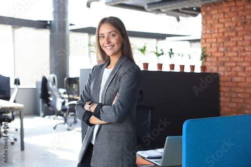 Attractive business woman smiling while standing in the office.