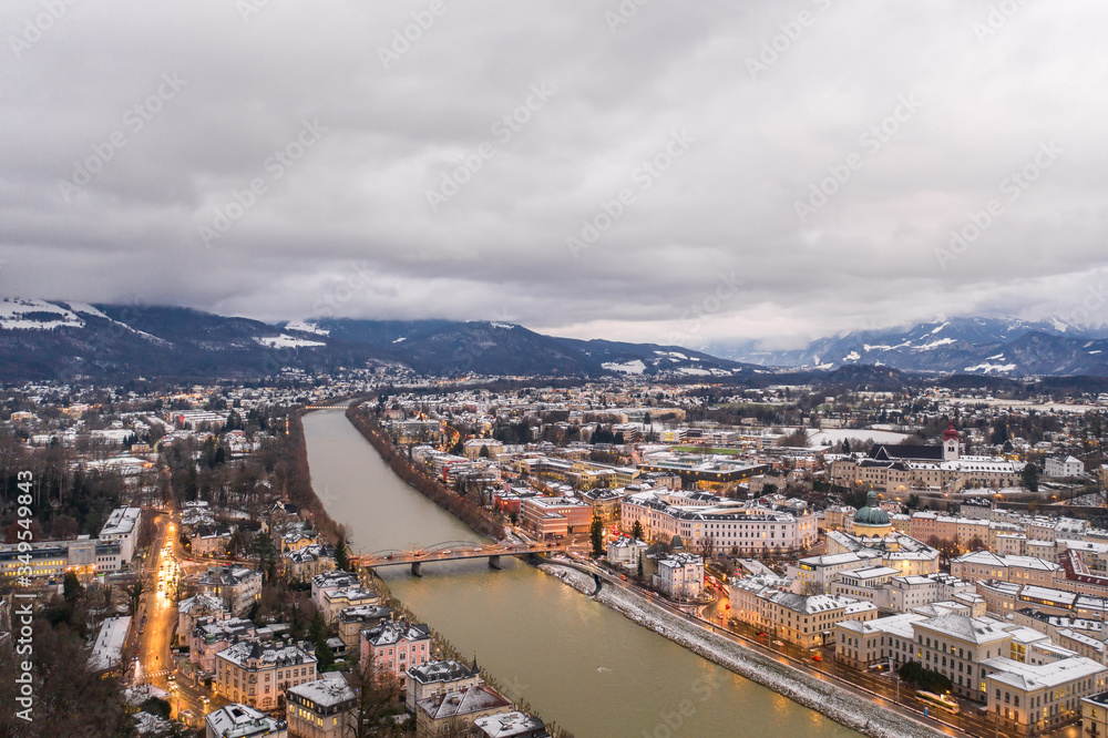Aerial drone overview of eastside of Salzburg old town along Salzach river in Austria in winter