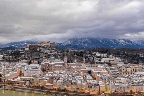 Aerial drone overview of Salzburg old town skyline covered with snow and view of Hohensalzburg in Austria winter