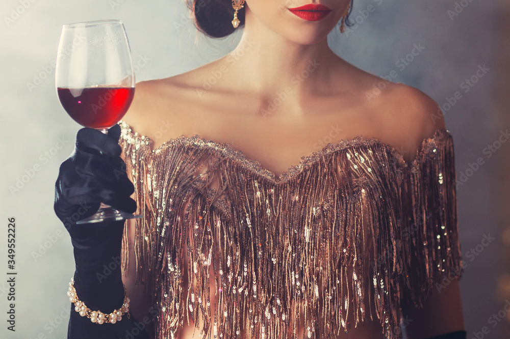 Fototapeta Piękna kobieta z seksownymi czerwonymi ustami trzymająca w ręku kieliszek czerwonego wina