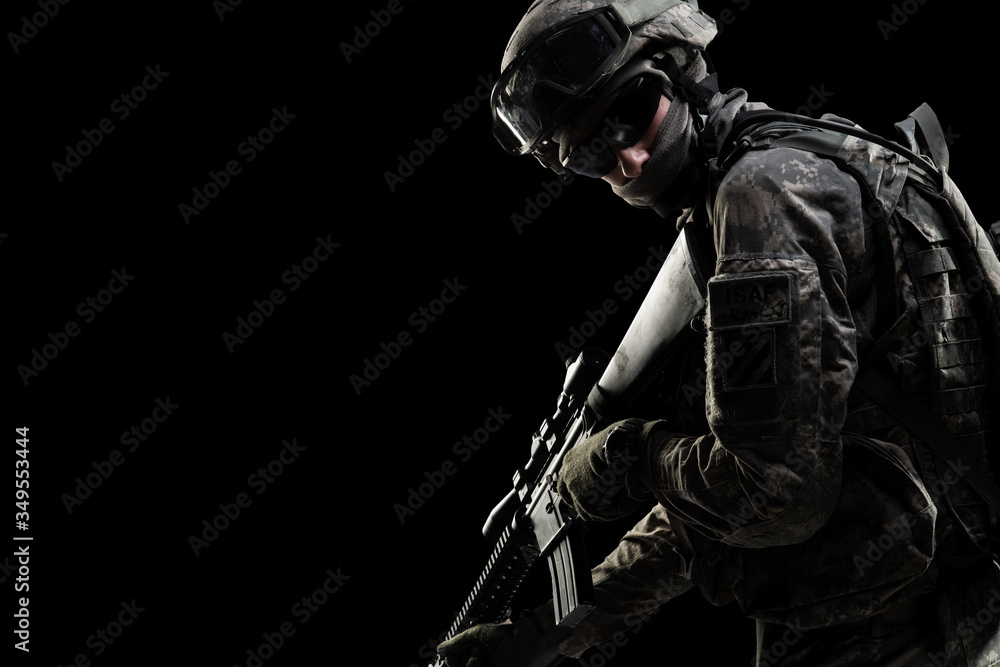 Male in US Army uniform soldier (Flag of the ISAF on the shoulder). Shot in studio. Isolated with clipping path on black background
