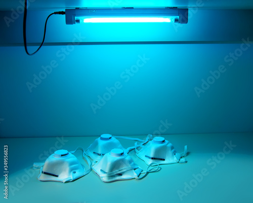 Protection and safety of medical workers.Protective masks N95 are sterilized under ultraviolet light  to disinfect and reuse. UV sterilization of ffp3 respirators. COVID-19 prevention concept.
