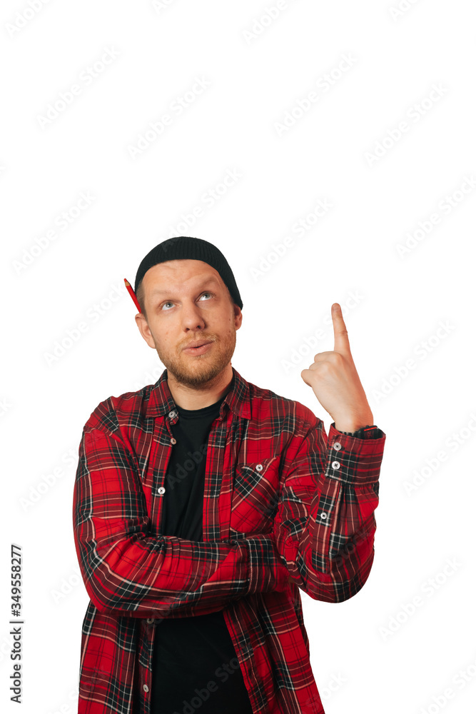 Vertical portrait of a caucasian successful builder, on a light background. a man in a plaid shirt points up Vertical portrait of a caucasian successful builder, on a light background. a man in a plaid shirt points up