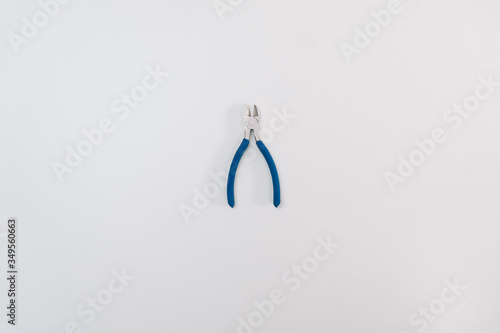 Blue new pliers forceps on a white background isolation. Copy space on top. Construction Tools Sale Concept photo