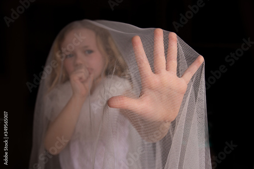 Niña, mujer joven cubierta por tela médica protectora mirando a la cámara , tosiendo y enseñando la mano para protegerse y parar el virus, concepto de coronavirus . photo