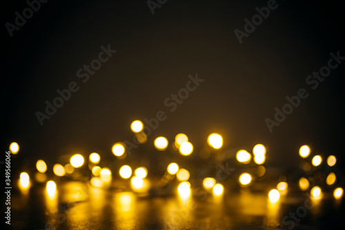 Lights in bokeh background. Yellow and gold lights in bokeh on a black dark background. Holiday, background decoration concept.