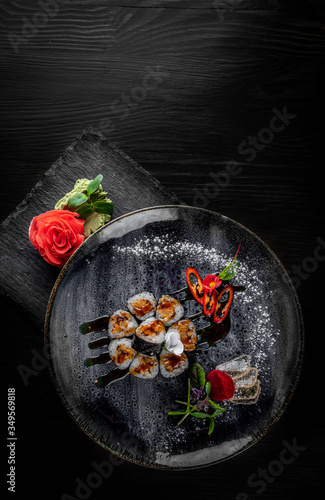 sushi roll with eel and rice in plate on black wooden table background