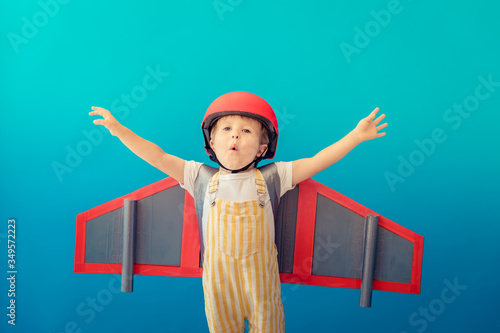 Happy child playing with toy paper wings