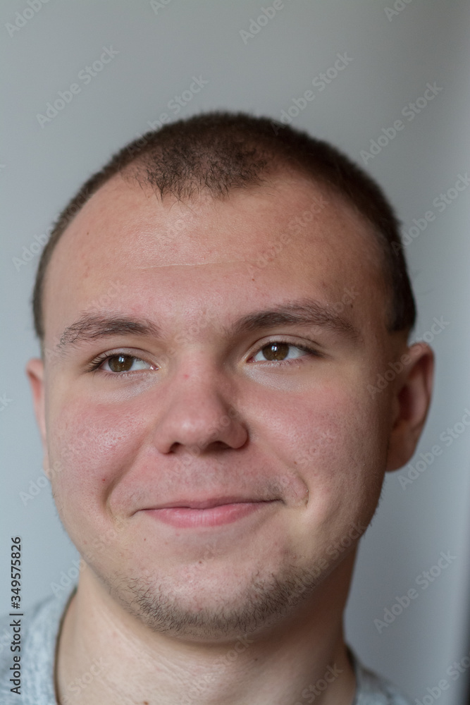 Emotions. The teenager smiles, expressing happy emotions on his face Emotions. The teenager smiles, expressing happy emotions on his face