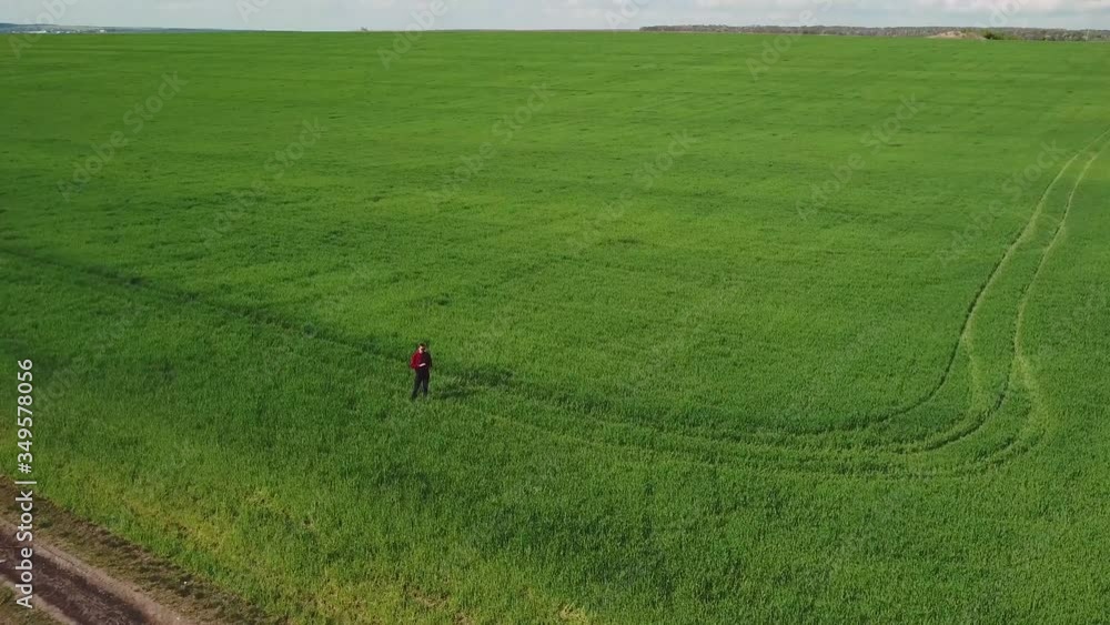 Farmer inspects wheat growth. Fresh green wheat field. Digital tablet in man's hand Farmer inspects wheat growth. Fresh green wheat field. Digital tablet in man's hand
