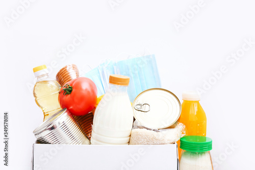 Donation box with food supplies for the period of quarantine on white background. Set of grocery items from canned food, vegetables, cereal. Food delivery concept.