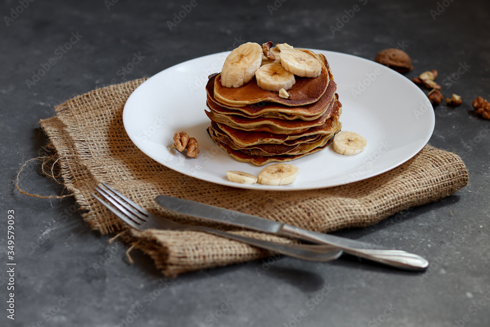 Protein pancakes with banana and walnut on a dark background. Protein pancakes with banana and walnut on a dark background.