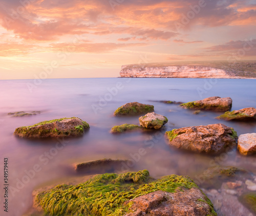 stony sea coast at the dramatic sunset