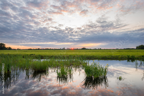 Tela Clouds over the wide open dutch polder landscape at sunset