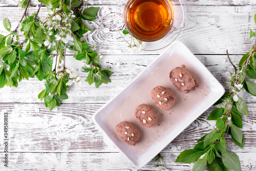 Kartoshka cake on the ceramic platter on the white wooden table. Russian potato-shaped dessert photo