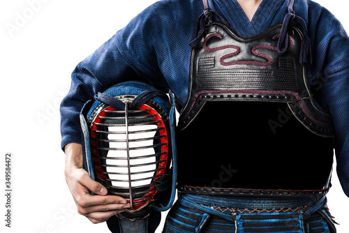 Male in in tradition kendo armor with helmet in hand. shot in studio. isolated on white background