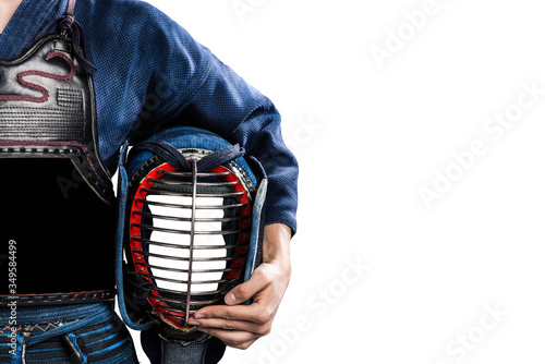 Male in in tradition kendo armor with helmet in hand. shot in studio. isolated on white background