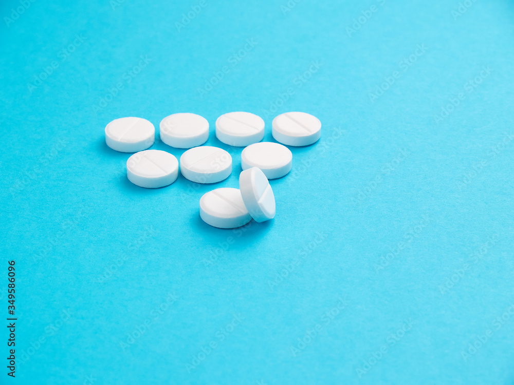 White pills on blue background copy space White pills on blue background copy space