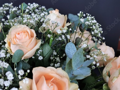 Apricotfarbene Rosenblüten mit Schleierkraut im Blumenstrauß photo