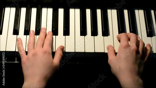 hands of a girl playing piano - top view
