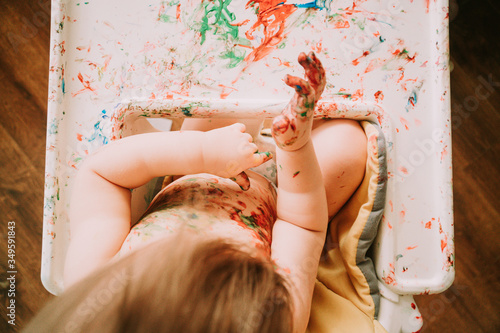 Top down view of baby girl playing with paint