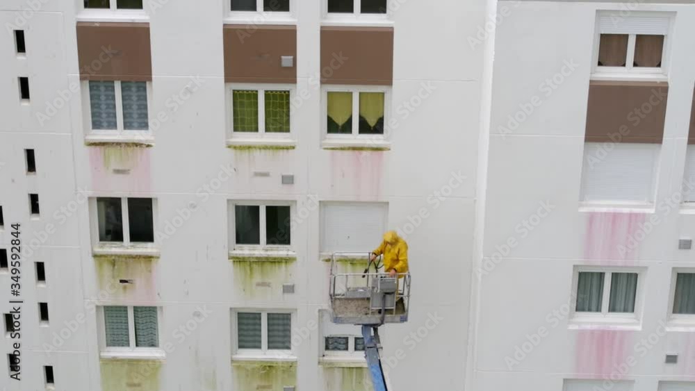 Homme utilisant un nettoyeur haute pression sur une nacelle Homme utilisant un nettoyeur haute pression sur une nacelle