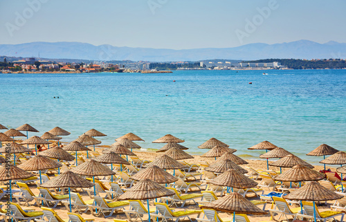 Empty sunbeds on ilica beach by the open sea, Cesme photo