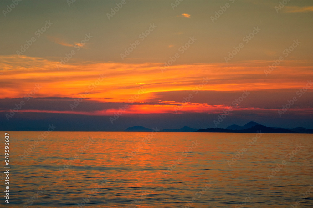 tramonto rosso sul mare con isola in croazia