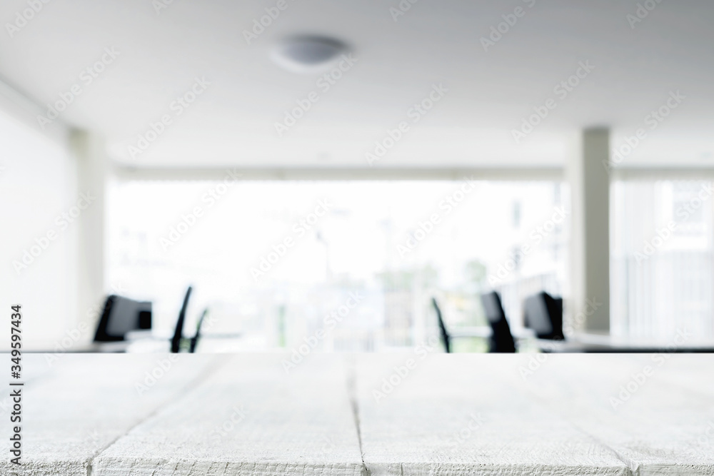 Fototapeta premium Desk space over blurred office or meeting room background. Product display.