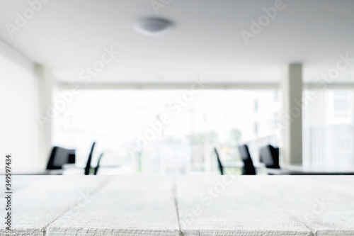 Desk space over blurred office or meeting room background. Product display.