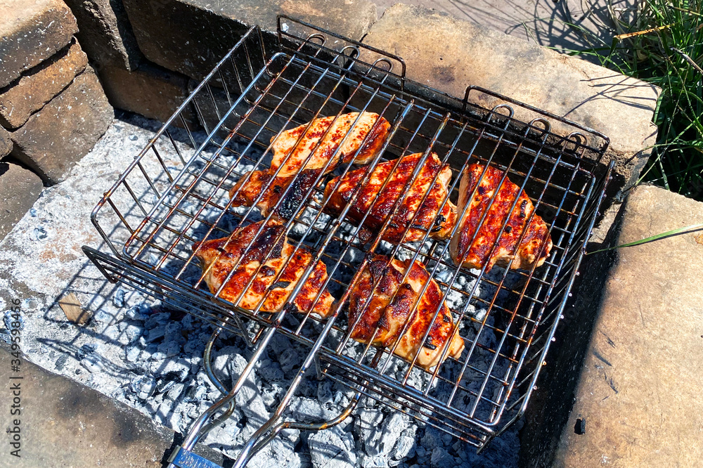 Close-up on the process of cooking shashlik, shish kebab roasted over charcoal on grill