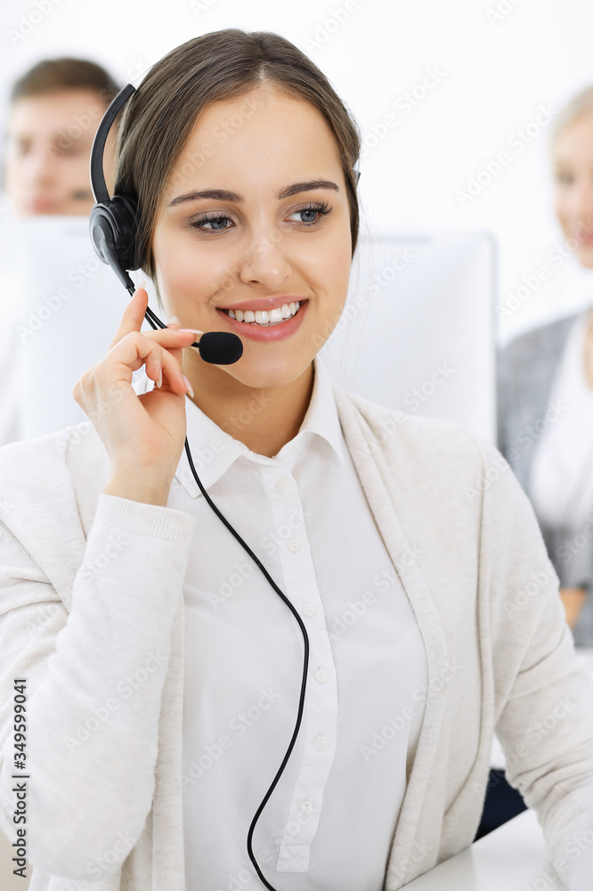 Call center. Group of diverse operators at work. Beautiful woman in headset communicating with customers of telemarketing service. Business concept Call center. Group of diverse operators at work. Beautiful woman in headset communicating with customers of telemarketing service. Business concept