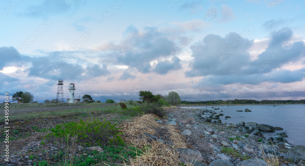 Sunset in Cape Neeme. Blue hour in Southern coast of Finnish Gulf (Baltic Sea). Old lighthouse and watchtower on the northern beach in Estonia. Colorful dawn in skies and water. Smooth surface.